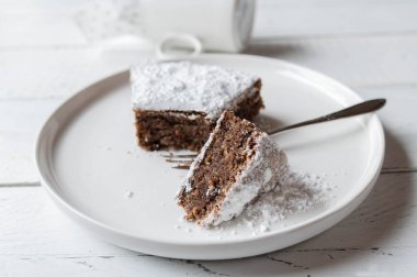 Torta caprese, gluten free, italian chocolate, almond cake on a white plate. Closeup and front view
