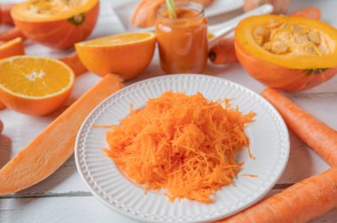 Oranged colored vegetables and fruit on white background. Closeup and front view