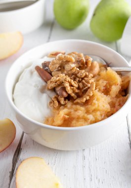 Grain free and gluten free breakfast bowl with greek yogurt, grated apples and nuts for healthy eating or low carb diet on white background