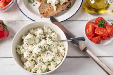 Terbiye edilmiş Feta peyniri ya da otlu koyun peyniri ve zeytinyağı salata için servis edilen beyaz masada kızarmış ekmek.