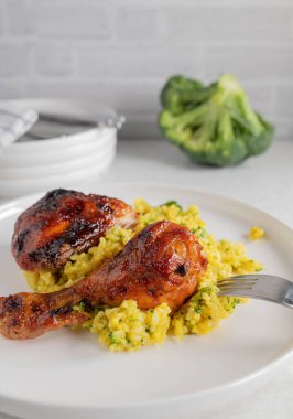 Körili pilav ve brokoliyle kaplanmış tavuk.