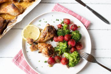 Düşük karbonhidratlı akşam yemeği fırında tavuk ve sıcak kırmızı turp, tabakta brokoli salatası.