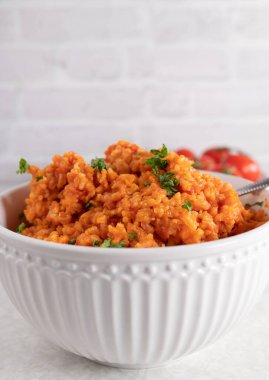 Açık arkaplanda izole edilmiş beyaz bir kasede Yunan domates esmer pirinci