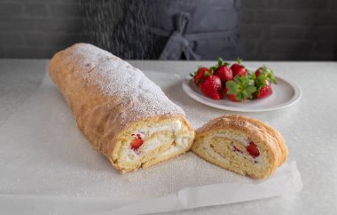 Fırında pişmiş İsviçre böreğinin üzerine pudra şekeri serpiyorum.