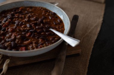 Biftekli fasulye güveci, fırında fasulye, dolma biber, soğan, sarımsaklı otlar, tabakta domates.