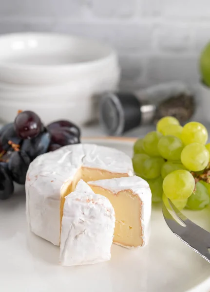 Stock image Soft cheese or brie with dark and green grapes