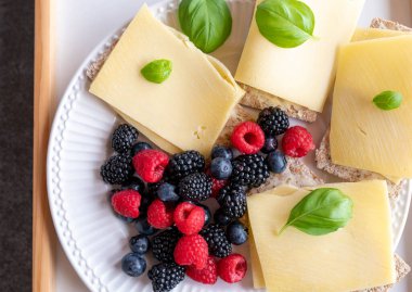 Az karbonhidratlı, tereyağlı ve bayat gouda peynirli sandviç. Taze böğürtlenlerle servis edilir