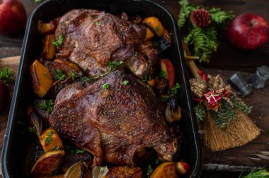 Kızarmış hindi inciği, tereyağlı kabak, ahşap masa üzerinde elma ve soğan bulunan kümes hayvanları..