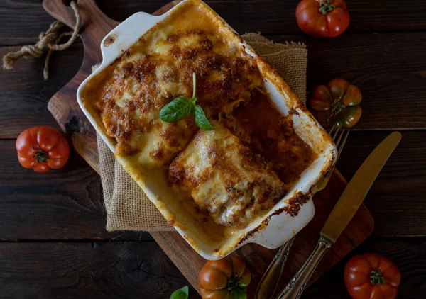 stock image Lasagne with bolognese sauce and bechamel sauce with mozzarella cheese topping on rustic and wooden table from above