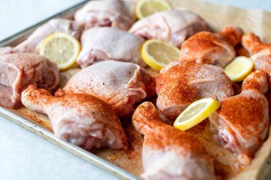 Çiğ tavuk inciği ve but çubukları. Pişirme tepsisinde çeşnili ve baharatsız. Seçici odaklı yakın plan