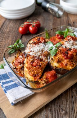 Esmer pirinç, ton balığı, domates sosu ve rendelenmiş parmesan peyniri ile doldurulmuş patlıcan..