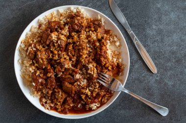 Tabağında kahverengi pirinç olan Ragout.