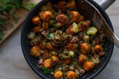 Tavada kızarmış sebze ve kızarmış domuz etli patates. Üst görünüm