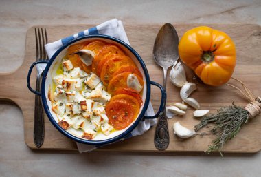 Fırında fırın peyniri, zeytinyağı, otlar ve domatesler. Sıfır ziyan