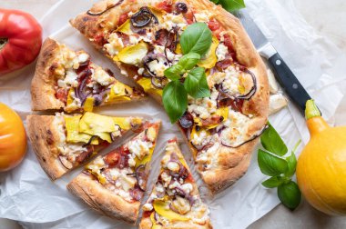 Sarı kabak, soğan, domates, duroc salam ve peynir gibi organik malzemeli ev yapımı pizza..