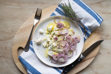 Zeytinyağı, sarımsak, kekik ve kırmızı soğanlı marine edilmiş peynir.