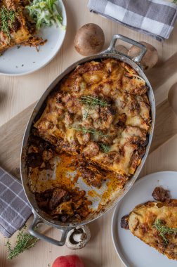 Lazanya erişteli güveç, haşlanmış ve doğranmış et, mantar ve peynir kızartma tavasında.
