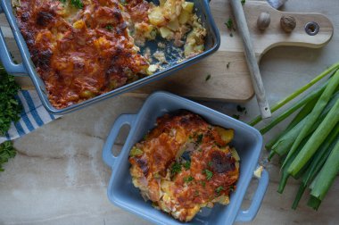 Jambonlu patates güveci, pırasa, yumurta ve güveç kabında domates peyniri.