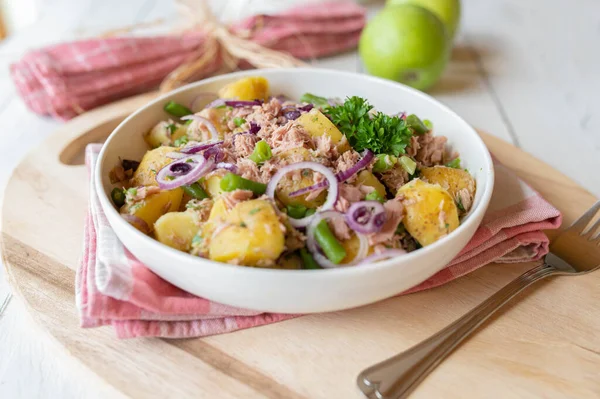 Patates, yeşil fasulye ve kırmızı soğanlı sağlıklı ton balığı salatası zeytin yağı, limon suyu ve bitkilerle marine edilmiş..