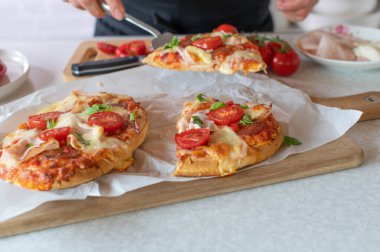 Mutfaktaki spatulada bir parça pizza servis eden kadın.