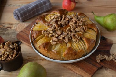 Armutlu sünger kek ve ahşap masada karamelli ceviz.