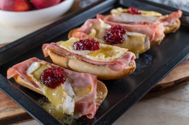 Jambonlu ve peynirli sandviç, camembert, jambon ve kızılcık kompostosu. Taze ve sıcak baget ekmeğinde servis edilir..