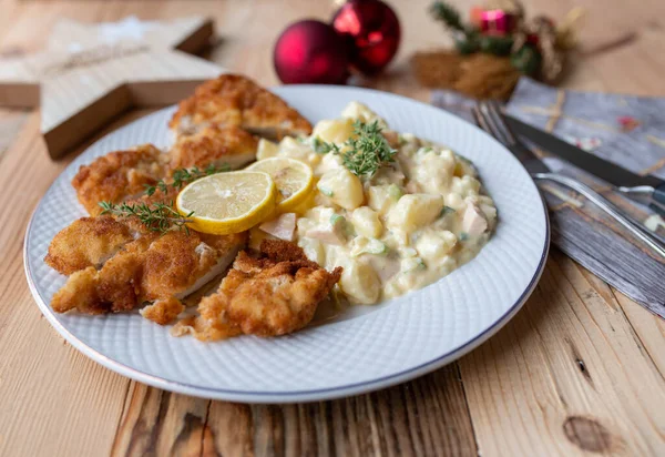 German christmas eve dinner  with homemade potato salad and breaded schnitzel on a plate