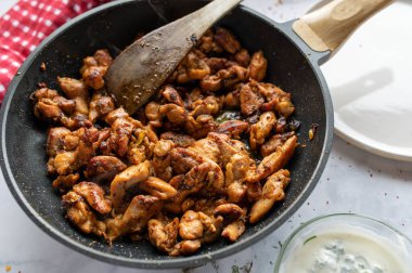 Lezzetli ev yapımı jiroskoplar, lezzetli baharatlı kızarmış Yunan et yemeği. Arka planda kızartma tavasında yemeye hazır. Yakın çekim.