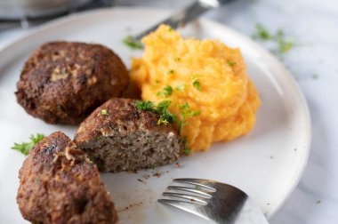 Glütensiz yemek tabağı. Tabakta patates püresi ve tatlı patatesli Alman köfteleri. Geleneksel mutfak