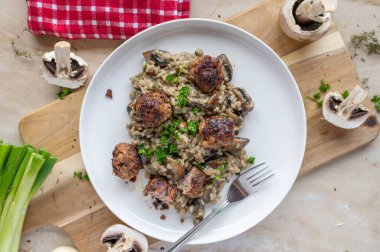 Mantarlı risotto ve İsveç köftesi ya da süslü masa arkaplanlı garnitürlü tabakta kttbullar..