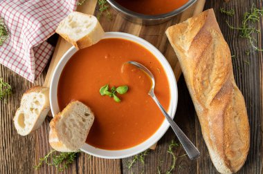 Lezzetli İtalyan püre domates çorbası ve yukarıdan ahşap masa arkaplanı.