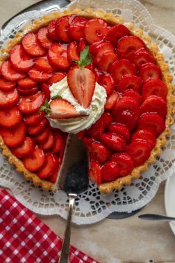 Çilekli kurabiye. Geleneksel Alman kısa hamurlu pastası. Mutfak masasının arka planında çilek var..