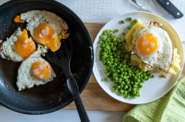 Sağlıklı vejetaryen yemeği, kızarmış yumurta, güneşli tarafı, patates püresi ve bezelye. Tablo üstü görünümü
