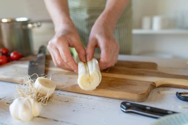 Mutfaktaki kadın elleriyle yaprakları temizlemek için pırasayı parmakları ayırın.