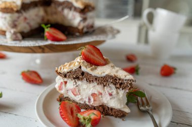 Süslü masa arkasında çikolatalı çilekli pasta.