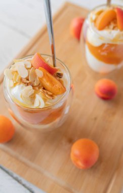 Taze kayısı kompostosu, gökyüzü ve gözlüklü kavrulmuş bademle Yaz Tatlısı. Protein yiyecekler sağlıklı yemek için, fitness diyeti için