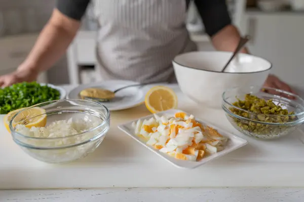 stock image Woman in the kitchen with ingredients for making a tartar sauce.