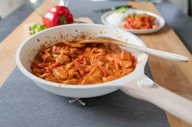 Paprikalı kremalı tavuk, tomtato soslu... Akşam yemeği masasının arkasındaki tavada yemek için hazır..