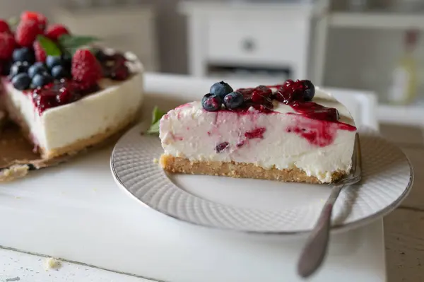 stock image Piece of no bake cheesecake with berry topping on kitchen counter