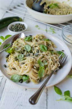 Lezzetli kabaklı spagetti ile sağlıklı vejetaryen makarna tabağı, parmesan sosu ve kabak tohumu, bir tabakta fesleğen.