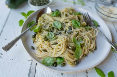 Lezzetli kabaklı spagetti ile sağlıklı vejetaryen makarna tabağı, parmesan sosu ve kabak tohumu, bir tabakta fesleğen.