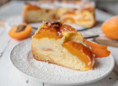 Beyaz bir masada ev yapımı kayısılı cheesecake..