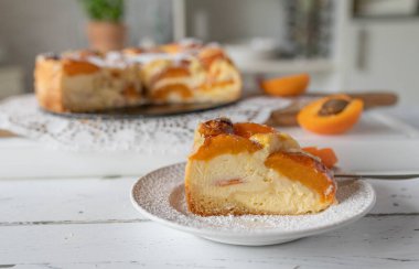 Beyaz bir masada ev yapımı kayısılı cheesecake..