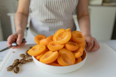 Kadınların elleri mutfakta taze kayısılar hazırlıyor.