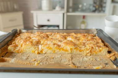 Mutfaktaki bir tepside mandalinalı ve bademli çarşaf pastası.
