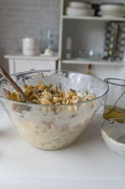 Geleneksel Alman makarna salatası mutfakta mayonez, turşu, sosis, bezelye ve yumurtalarla hazır. Ev yapımı yemek.