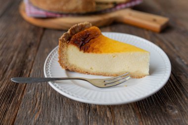 Delicious piece of german rustic sour cream cake isolated on wooden table background. Old fashioned food