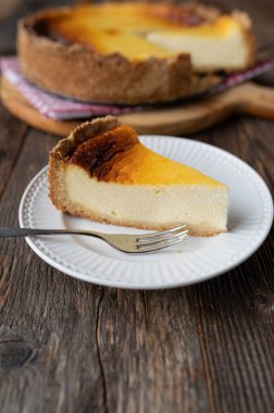 Tahta masada bir dilim ekşi kremalı pasta.