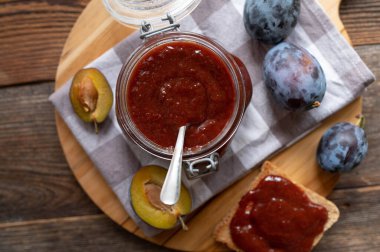 Alman erik yağı veya Pflaumenmus taze ve ahşap masa arkasında bir kavanozda pişirilmiş ev yapımı.