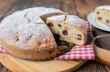 Ahşap masada izole edilmiş kirazlı pasta.